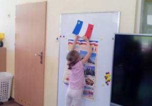 Dziewczynka przy tablicy z flagą Francji.